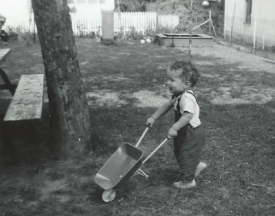 John truly grew up with construction in his DNA, as shown here act just eighteen (18) months, carting a wheelbarrow on the "job site"